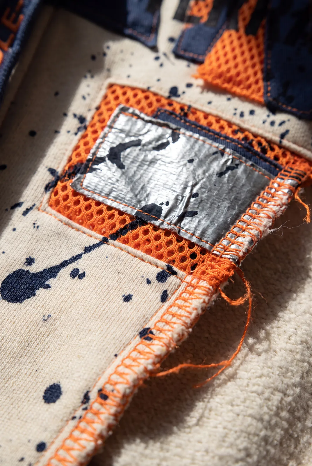 FIELD OPS HEADER Hoodie capsule. Detail · Foil Patch + Mesh.