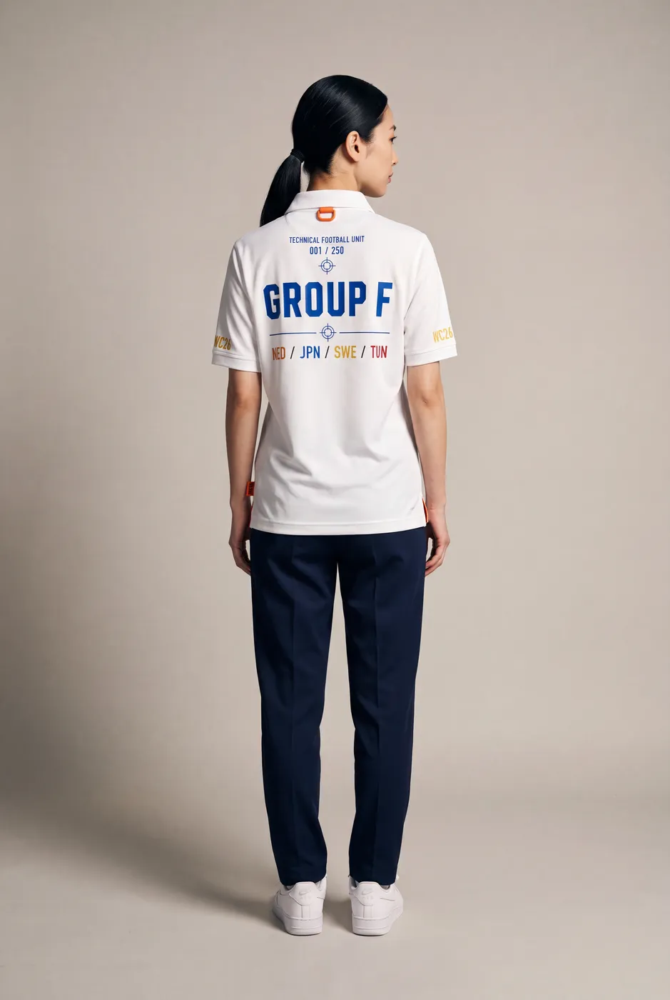 Group F polo worn on model, studio back.
